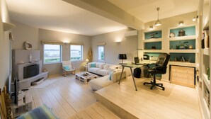 A modern living room with a fireplace, a sofa, a coffee table, and a TV. - A private Villa infront of the sea (Paros Island)
