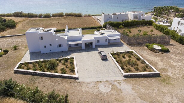 A white villa with a paved courtyard and a view of the sea. - A private Villa infront of the sea (Paros Island)