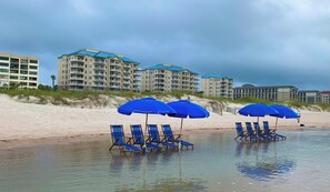 Rannalla, aurinkotuoleja, rantapyyhkeitä