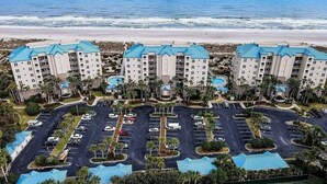 A beachfront hotel with multiple buildings, a parking lot, and a pool area. - Luxury 5th Floor Oceanfront Condo next to Ritz Carlton! (Fernandina Beach)