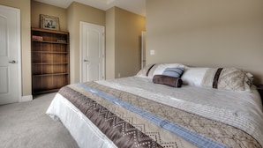 A bedroom with a large bed, a wardrobe, and a door. - Lake Life Luxury on the Water (Bean Station)