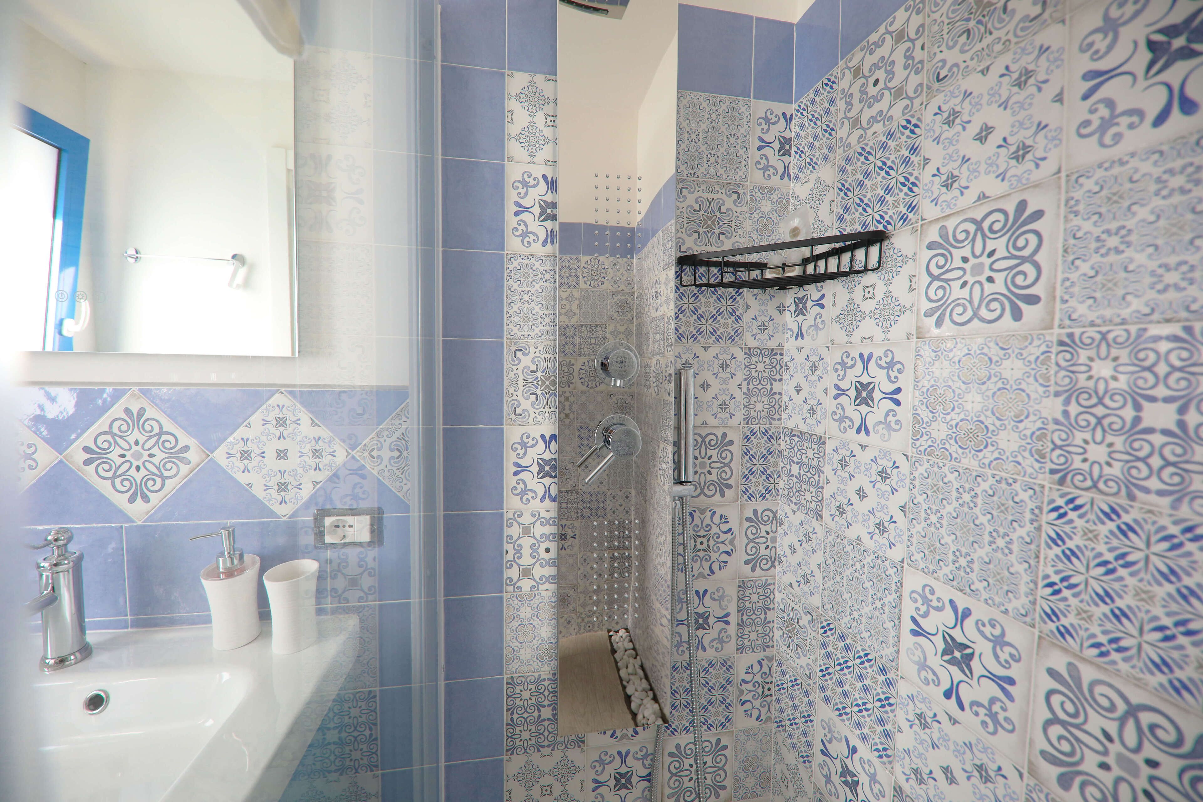 A bathroom with a sink, mirror, and shower.
