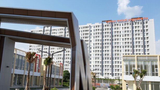 Un edificio moderno con una entrada destacada y un amplio frente de vidrio.