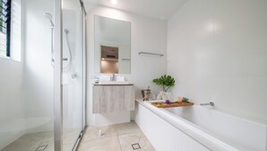 A modern bathroom with a glass shower enclosure, a white sink, and a bathtub. - Splendeur Sur La Mer (Three Bedroom) (Airlie Beach)