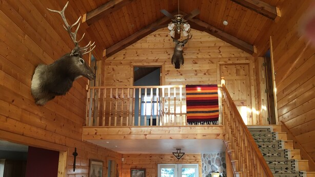 A wooden cabin with a loft bedroom, a dining area, and a fireplace. - 10 minutes to Slopes! Wild Turkey Lodge & Farm BnB, A 5-star traveler's dream! (Huntsville)