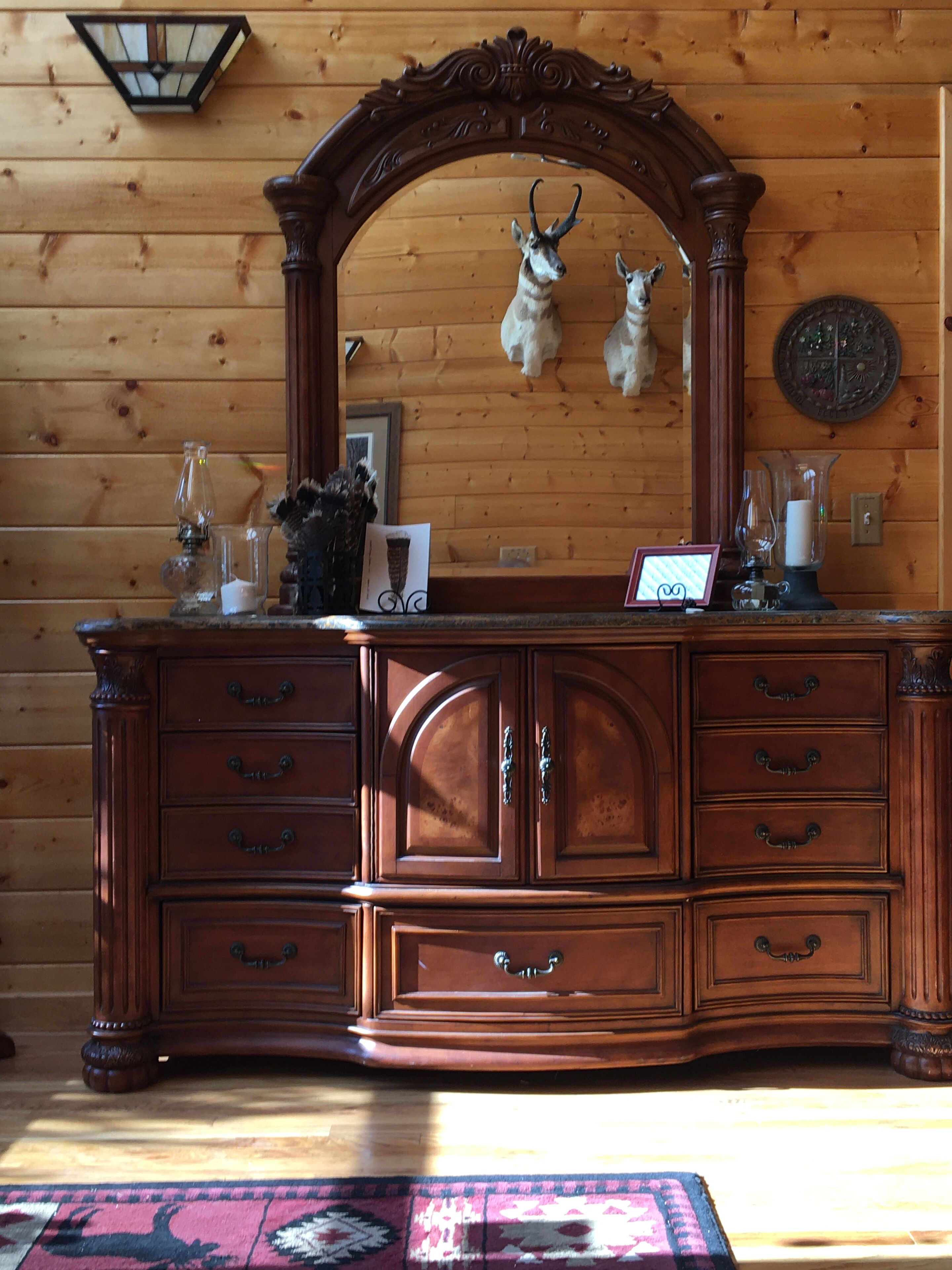 A wooden dresser with multiple drawers and a mirror above it.