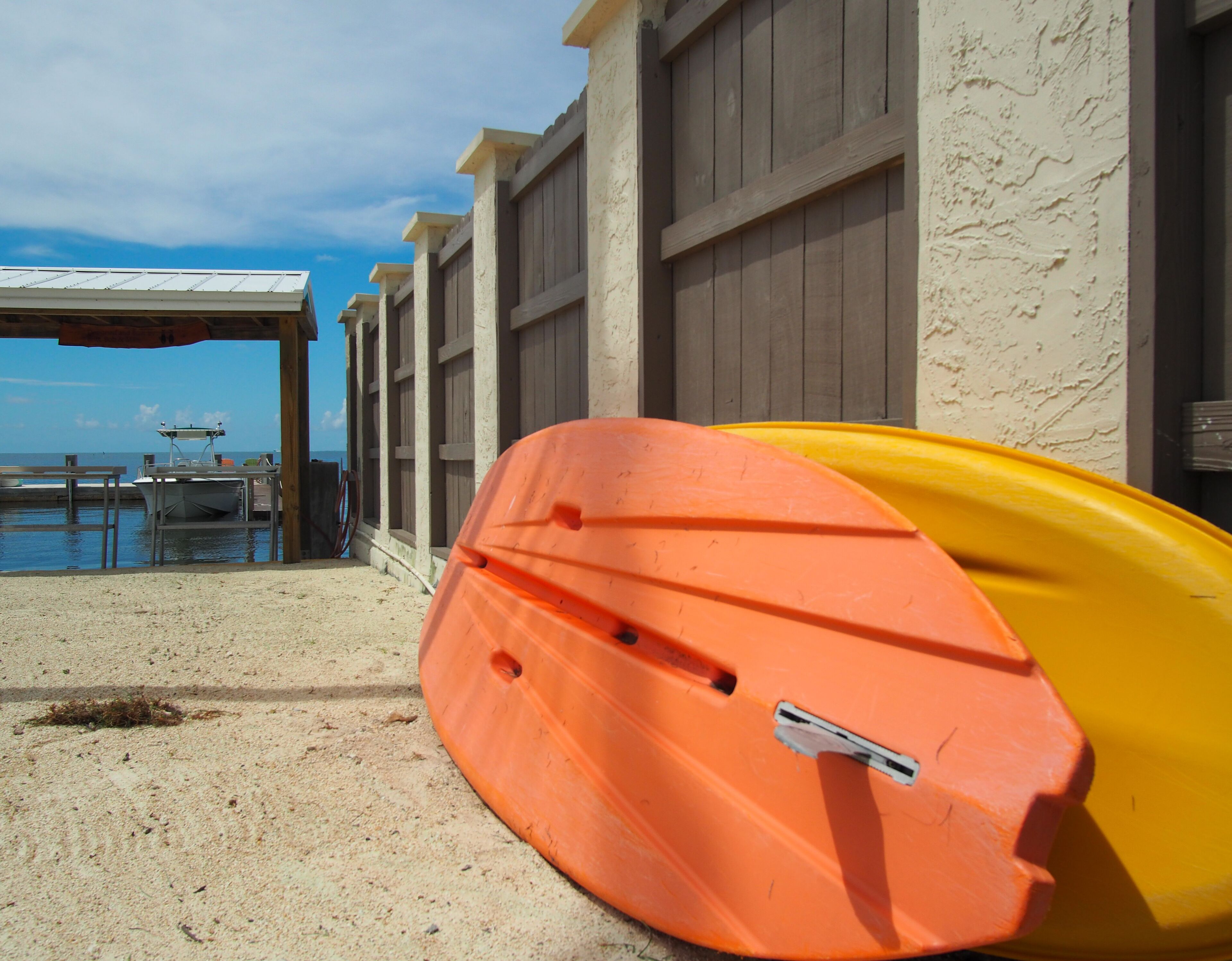 A beachside building with a covered seating area and a boat dock.
