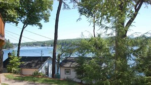 Un quartier résidentiel avec une maison, un banc et une vue sur un lac.