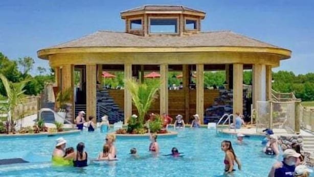 A pool area with a gazebo, palm trees, and people swimming. - Coastal Club * 6BR Lewes Beach House (Lewes)