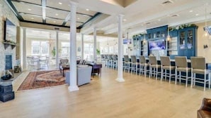 A spacious hotel lobby with high ceilings, a fireplace, and a seating area. - Coastal Club * 6BR Lewes Beach House (Lewes)