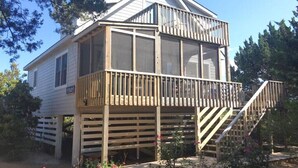 A two-story house with a balcony, a wooden deck, and a staircase leading to the upper floor. - JD36: Flyway | Multiple Decks with Amazing Marsh Views (Ocracoke)