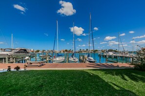 Un port de plaisance où sont amarrés de nombreux bateaux, une jetée en bois et un ciel d’un bleu limpide.