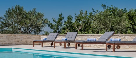 A heated pool, sun loungers