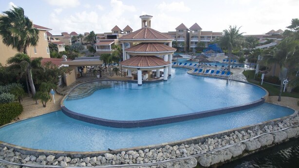 A resort with a central pool, a gazebo, and multiple buildings with a consistent architectural style.