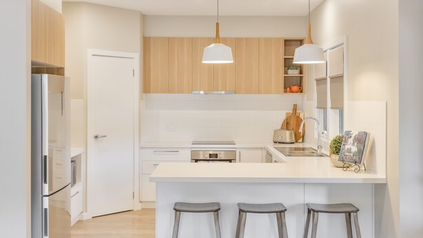 A modern kitchen with white cabinetry, stainless steel appliances, and a central island with bar stools. - Autumn Home, Our Place at Bright - Boasting commanding views of the surrounding landscape from the generous indoor/outdoor living spaces. (Bright)