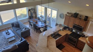 A spacious living area with a dining table, sofa, and kitchen with a built-in oven and microwave. - 3 Master Suites, Spa, Pool table, Game room, views (Tillamook)