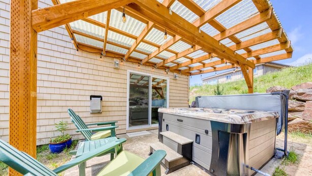 An outdoor patio with a grill, green chairs, and a pergola structure. - 3 Master Suites, Spa, Pool table, Game room, views (Tillamook)