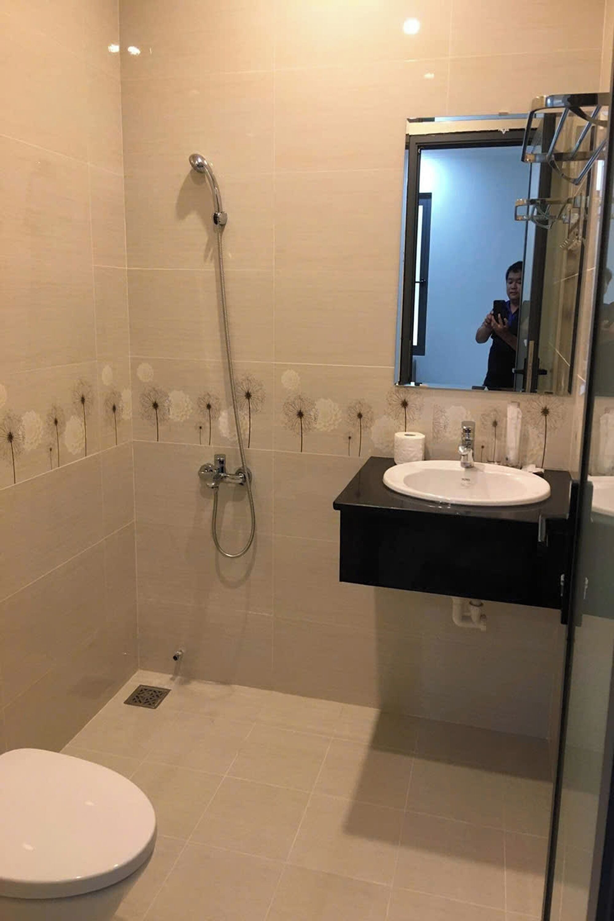 A modern bathroom with a shower, toilet, and sink.