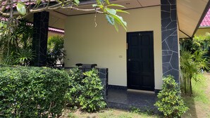 A house with a tiled roof, a black door, and a covered porch area. - Sirin Bungalow (Choeng Thale)