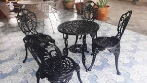 A patio area with a round table and four chairs, surrounded by potted plants. - Tyler Cherngtalay (Choeng Thale)