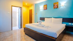 A hotel room with a bed, a door, and a wall with a painting. - Tyler Banpon (Si Sunthon)
