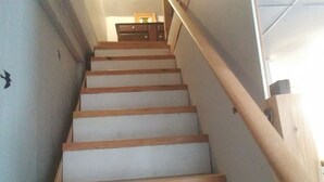A staircase with wooden steps and a handrail, leading to a room with a wooden dresser and a framed picture on the wall. - Escape to the Country! Sleeps 4 (Thomasburg)