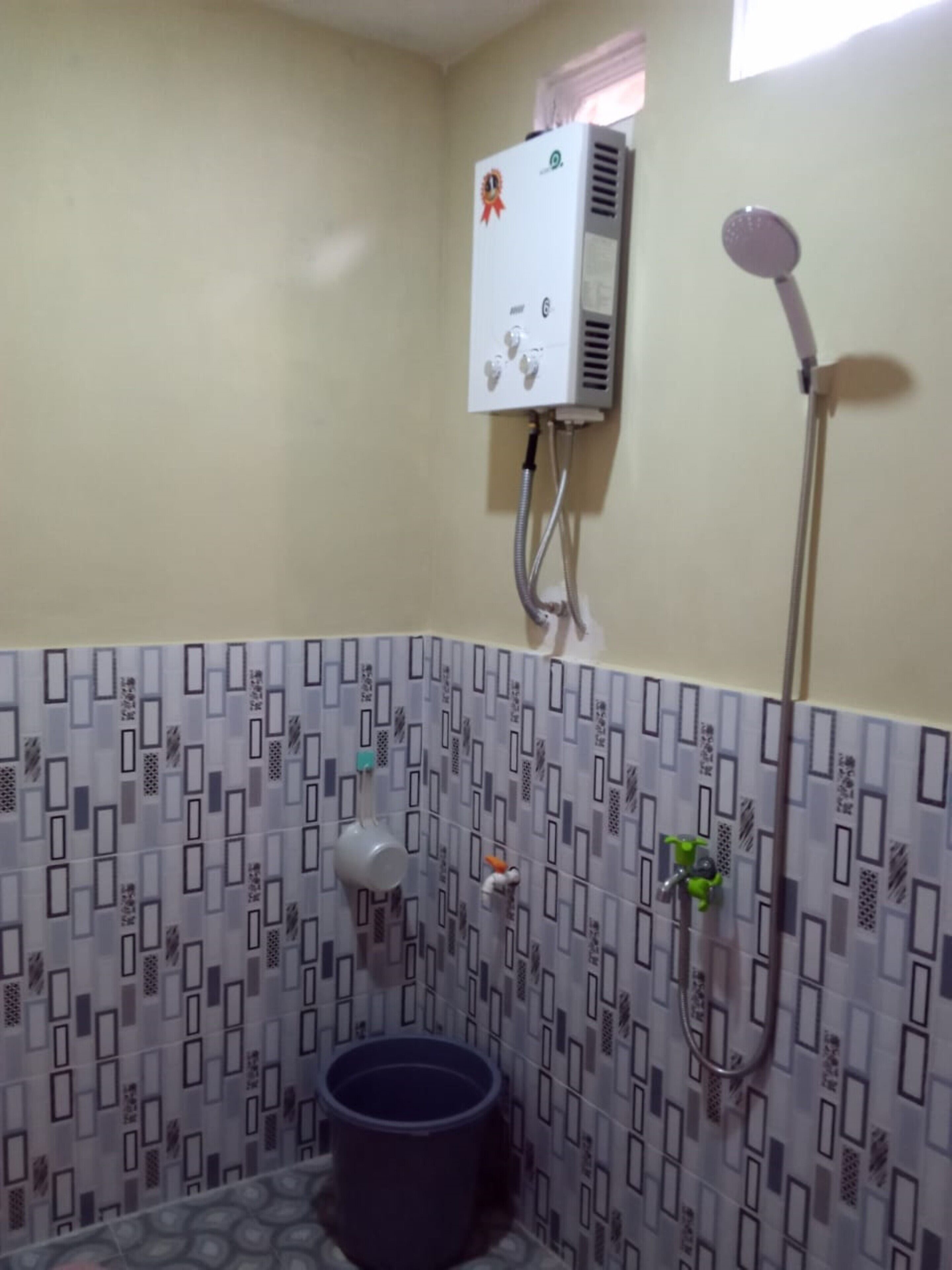 Une salle de bain équipée d’une douche, de toilettes et d’un radiateur fixé au mur.
