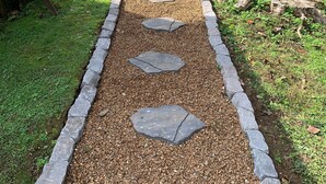 A pathway with stepping stones leading to a building.