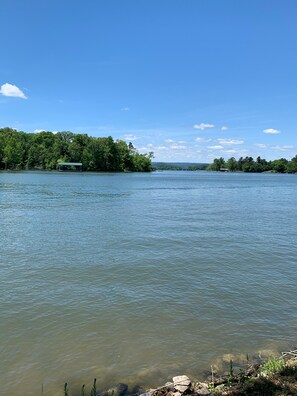 A calm lake with a dock and a covered area on the left.