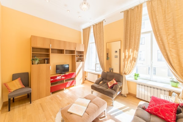 Relax in a cozy seating area with a sofa, chair, and flat-screen TV.