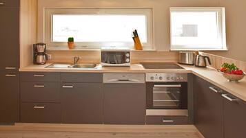 Eine moderne Küche mit Geschirrspüler, Backofen und Kaffeemaschine.