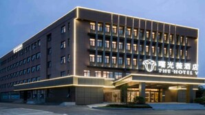 Un moderno edificio de hotel con una entrada destacada y señalización iluminada.