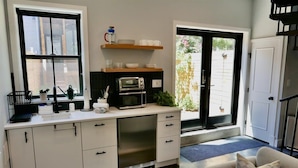 A compact kitchen with a built-in oven, microwave, and a small window.