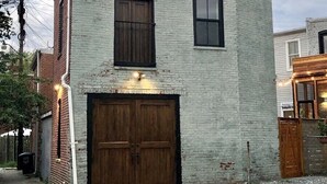A two-story building with a large garage door and two windows.