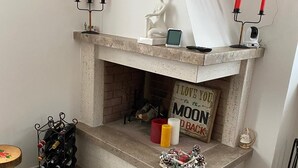 Ein Kamin mit einem Schild, auf dem steht "ICH LIEBE DICH BIS ZUM MOND UND ZURÜCK", ein Kerzenhalter und eine kleine Statue.