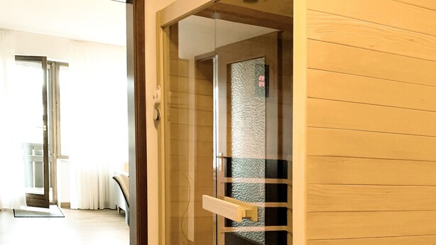 A room with a sliding glass door leading to a balcony, wooden flooring, and a visible door handle. - Ferienwohnung Fichtelzauber (Mehlmeisel)