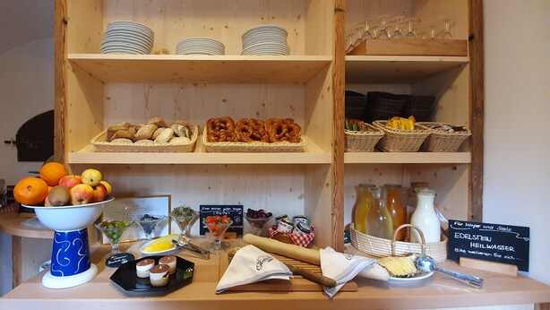 Un bufé de desayuno con diversas opciones de comida, como frutas, pasteles y bebidas.