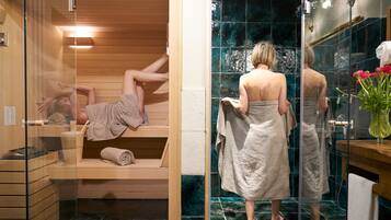 Relax in a serene bathroom with a glass-enclosed sauna, shower enclosure, and wooden vanity.