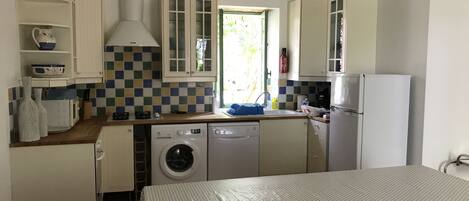 Efficient kitchen with appliances and dining area for two.
