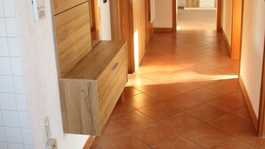 A hallway with wooden flooring, a built-in bench, and a hanging coat rack. - Ferienwohnung Friedrich (Schonungen)