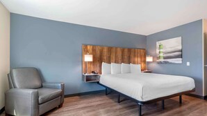 A modern bedroom with a bed, a chair, and a nightstand with lamps. - Extended Stay America Premier Suites Ukiah (Ukiah)