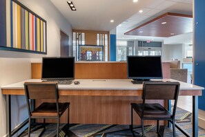 A workspace with two desks, each with a laptop and a keyboard, two chairs, and a patterned carpet. - Holiday Inn Express & Suites Carlisle Southwest – I-81 by IHG (Carlisle)