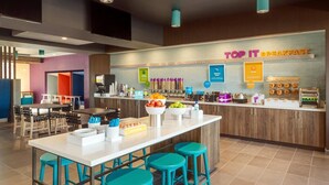 A modern breakfast area with a counter displaying various food items and a sign that reads "TOP IT BREAKFAST". - Tru by Hilton Fort Lauderdale Downtown (Fort Lauderdale)