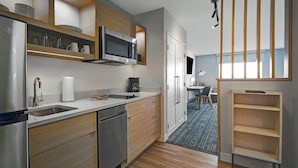 Una cocina moderna con electrodomésticos de acero inoxidable, armarios de madera y un microondas integrado.