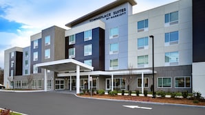 Un hotel moderno con entrada cubierta, varios pisos y un cartel que dice "Towneplace Suites by Marriott".
