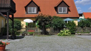 A traditional house with a red-tiled roof, two dormer windows, and a wooden fence. - Ferienwohnung Gäste Oase (Bad Windsheim)