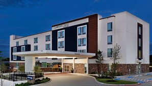 Un hotel moderno con techo plano, amplias ventanas y acceso cubierto.