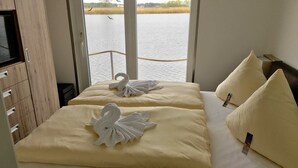 Ett hotellrum med två sängar, där varje säng har en handduk och en kudde formad som en svan.