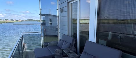 A deck with outdoor furniture and a view of the water.