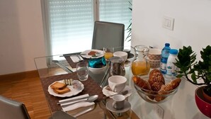 Une table de petit-déjeuner avec divers aliments, boissons et ustensiles.